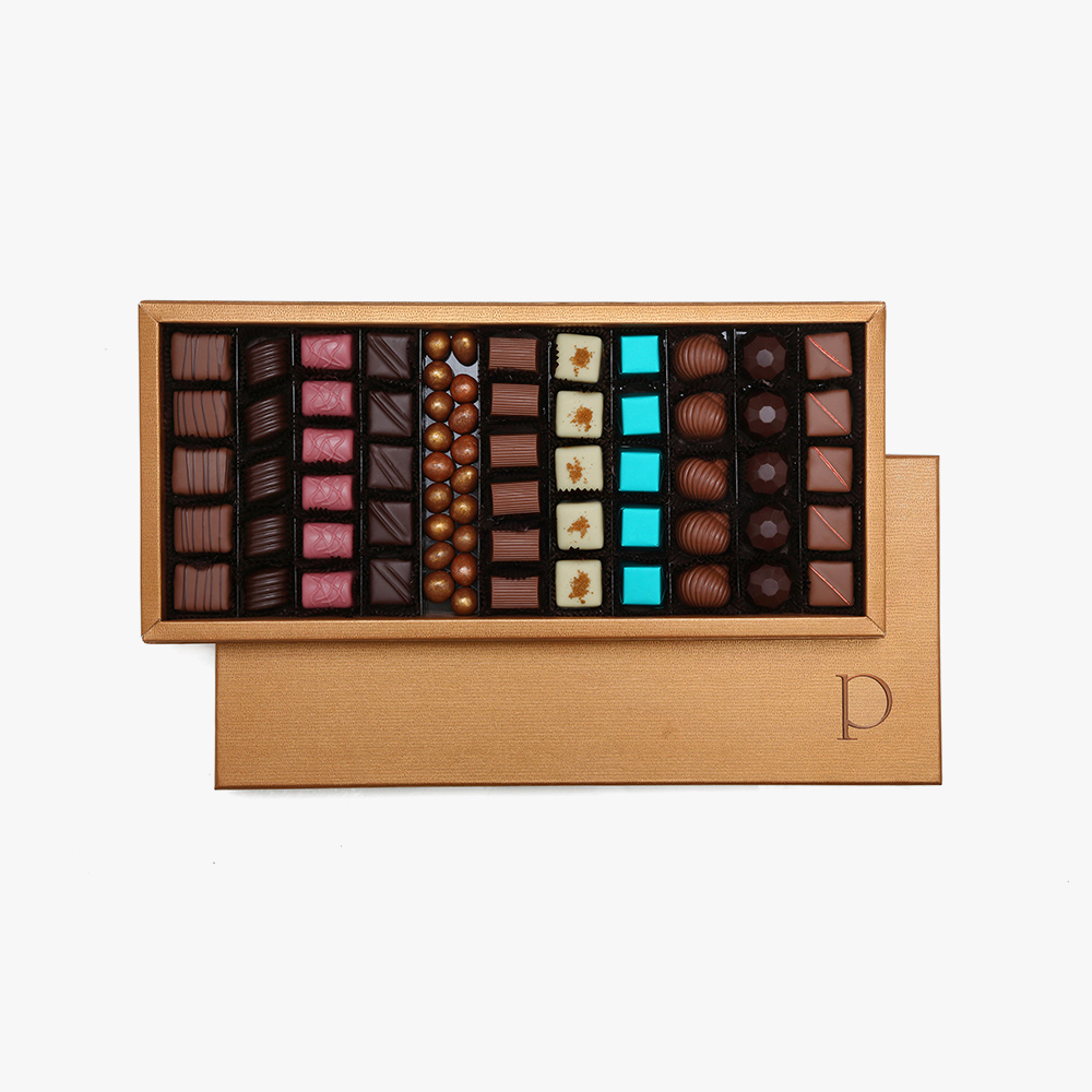 Prestige Supremo Laissez-vous séduire par l'élégance de ce coffret et l'authenticité des chocolats, créant ainsi une expérience gourmande inoubliable pour les amateurs de chocolat les plus fins. Savourez notre assortiment de <strong>750g </strong>offrant 11 variétés de saveurs exquises présenté dans un emballage rigide à l'effet cuir. 1 Prestige Supremo